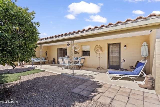 rear view of house featuring a patio and a tiled roof