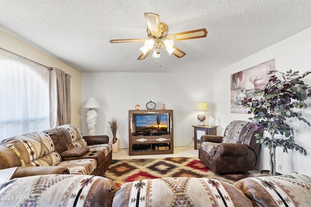 carpeted living area with a textured ceiling and ceiling fan