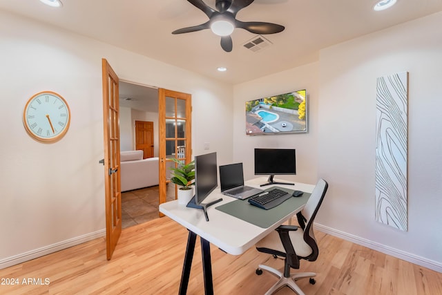 home office with french doors and light hardwood / wood-style floors