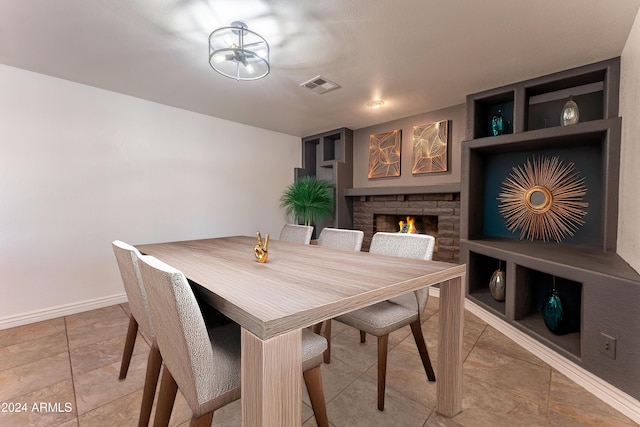 tiled dining area with a fireplace