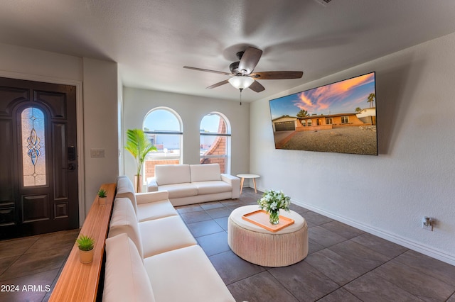 living room with dark tile patterned floors and ceiling fan