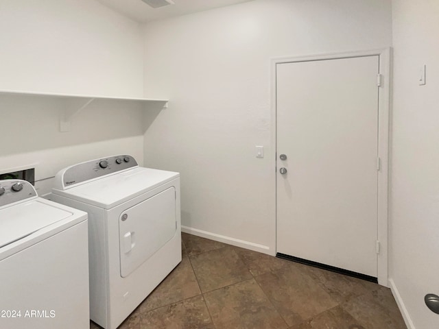 laundry area featuring dark tile patterned flooring and washing machine and dryer