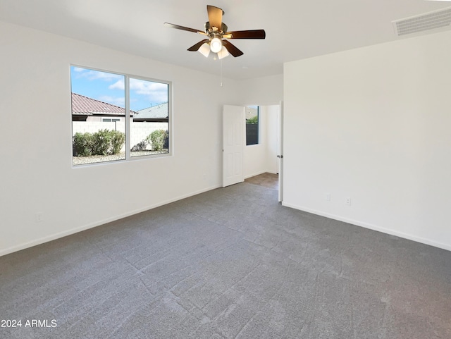 unfurnished room featuring dark colored carpet and ceiling fan