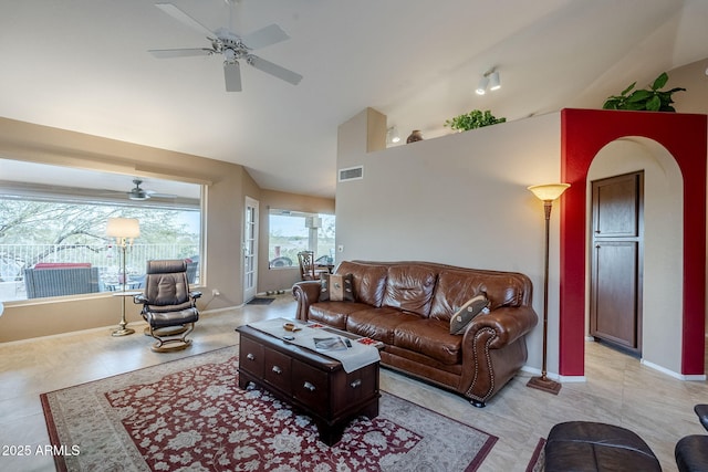 living room with ceiling fan, lofted ceiling, and light tile patterned flooring