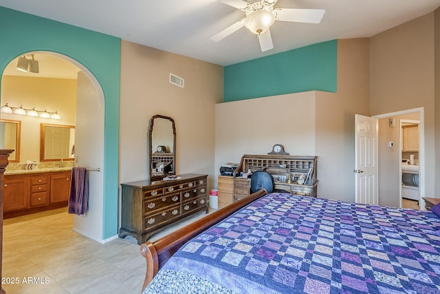 bedroom with ensuite bath, ceiling fan, and washer / clothes dryer