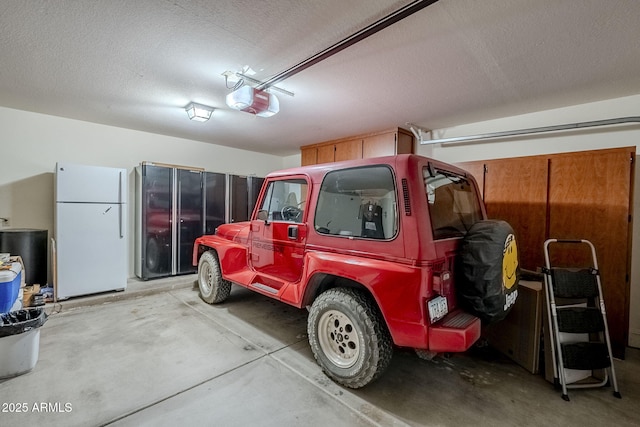 garage with white refrigerator and a garage door opener