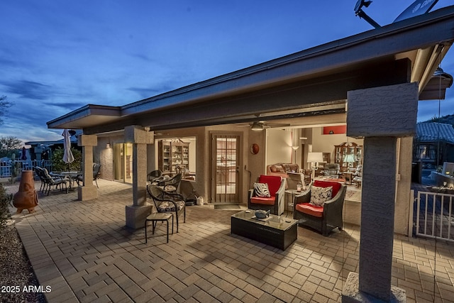 patio terrace at dusk featuring ceiling fan