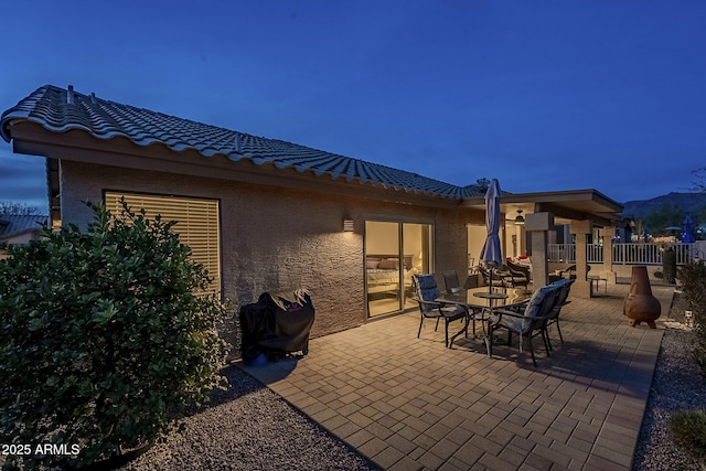 patio terrace at dusk featuring a grill