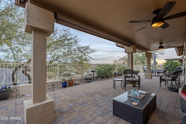 patio terrace at dusk featuring ceiling fan