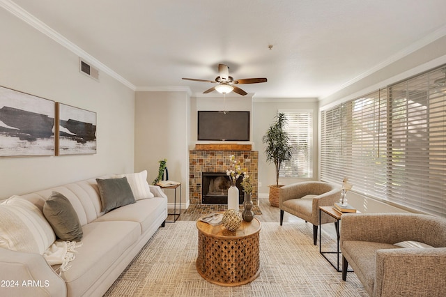 living room with a fireplace, hardwood / wood-style floors, ceiling fan, and crown molding