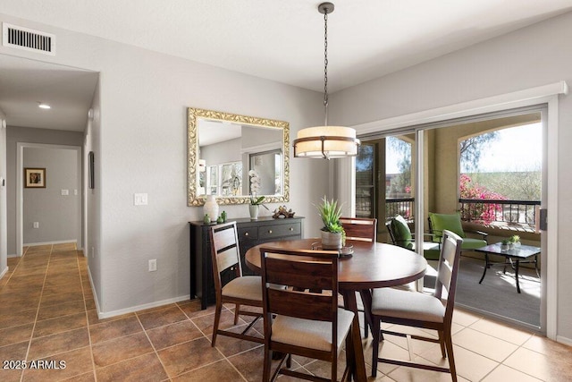 tiled dining space with baseboards and visible vents