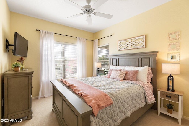 bedroom with light carpet, baseboards, and a ceiling fan