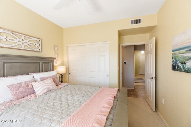 tiled bedroom with a ceiling fan, a closet, visible vents, and baseboards