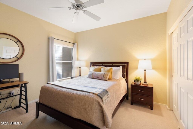 bedroom with a ceiling fan, light carpet, and baseboards