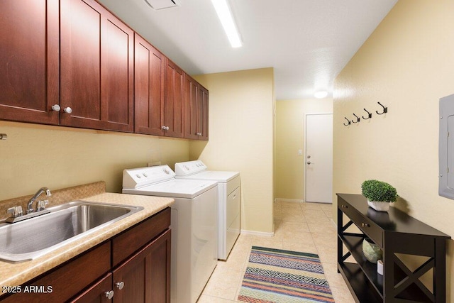 laundry room featuring cabinet space, light tile patterned floors, baseboards, washer and clothes dryer, and a sink