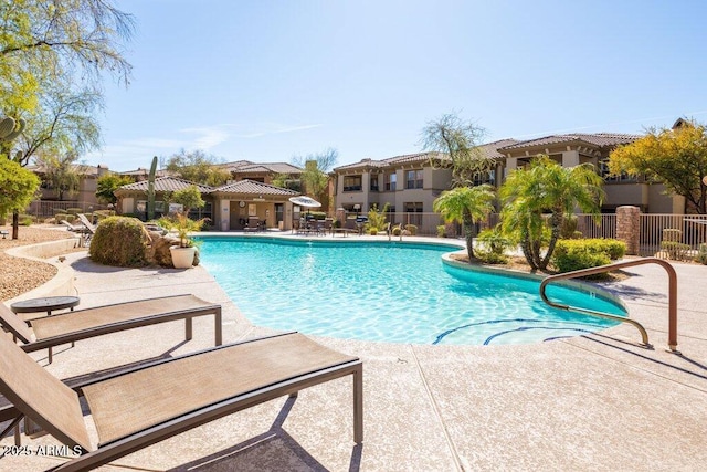 pool with a patio area and fence