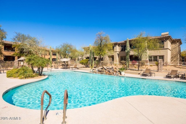 community pool with fence and a patio