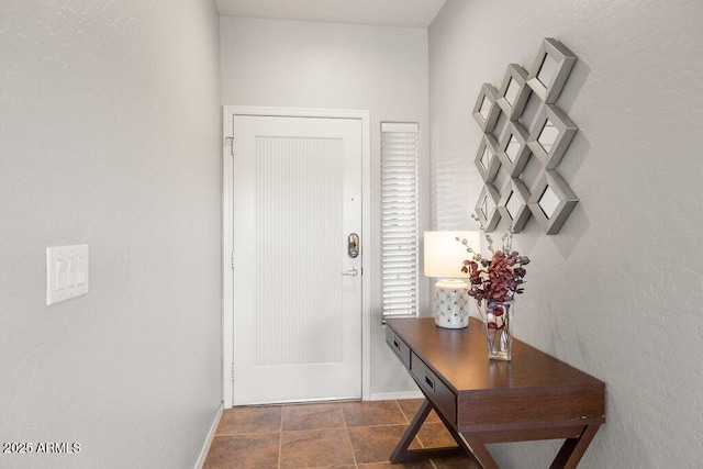 doorway to outside with baseboards