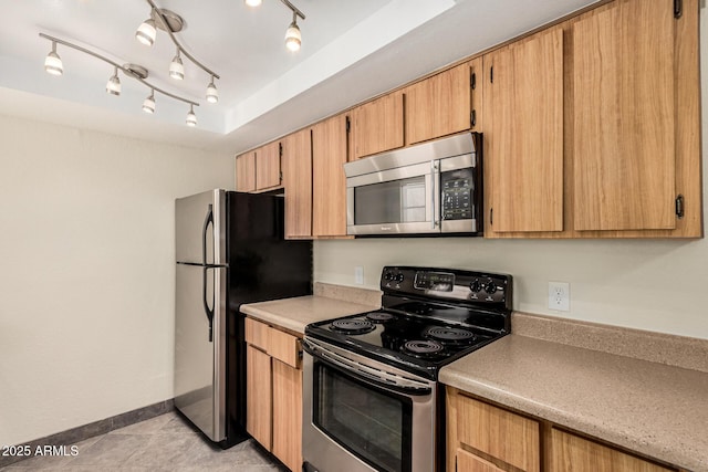 kitchen with light countertops, light tile patterned floors, baseboards, and appliances with stainless steel finishes