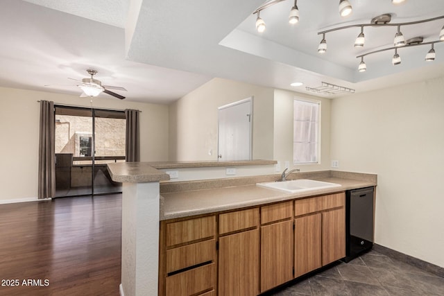 kitchen with a sink, light countertops, baseboards, dishwasher, and ceiling fan