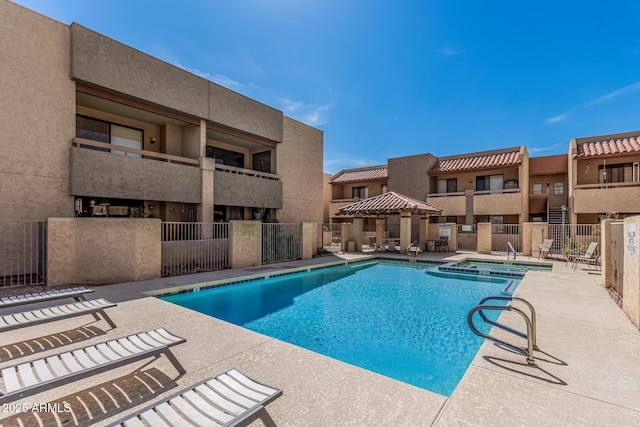 community pool with a patio and fence
