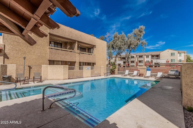 view of pool featuring a residential view, a patio, a pool with connected hot tub, and fence