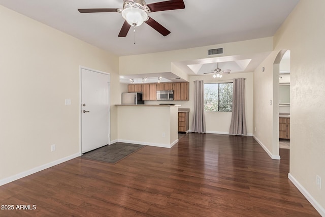 kitchen with visible vents, dark wood-type flooring, open floor plan, appliances with stainless steel finishes, and a peninsula