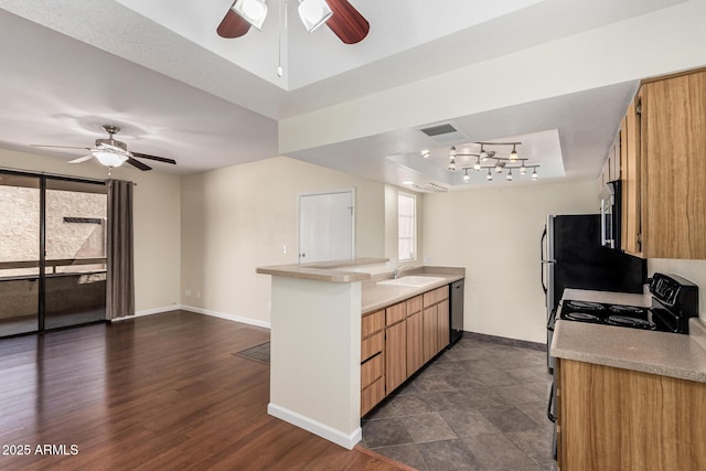 kitchen featuring a tray ceiling, a ceiling fan, and light countertops