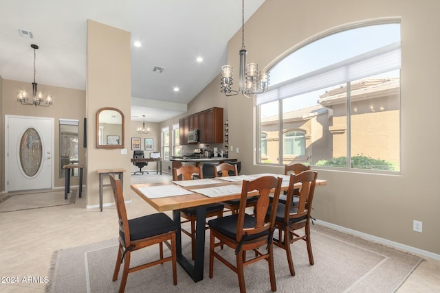 dining room featuring an inviting chandelier, high vaulted ceiling, and plenty of natural light