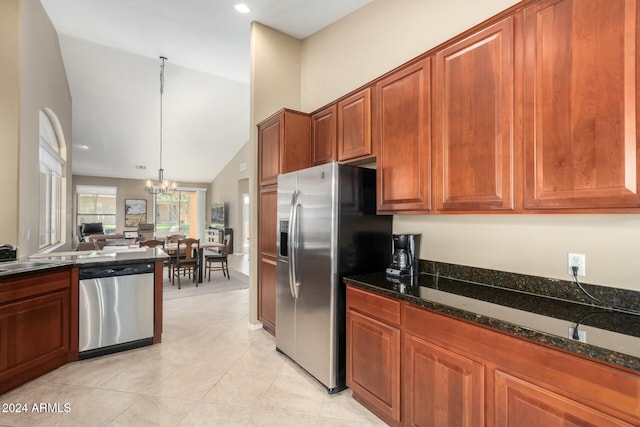 kitchen featuring pendant lighting, lofted ceiling, dark stone countertops, stainless steel appliances, and a chandelier