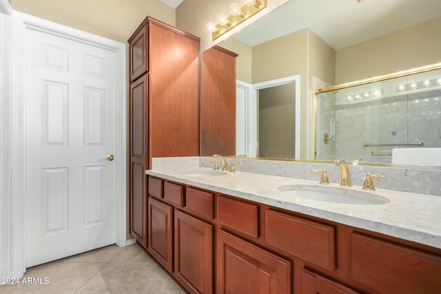 bathroom featuring tile patterned flooring, vanity, and a shower with door