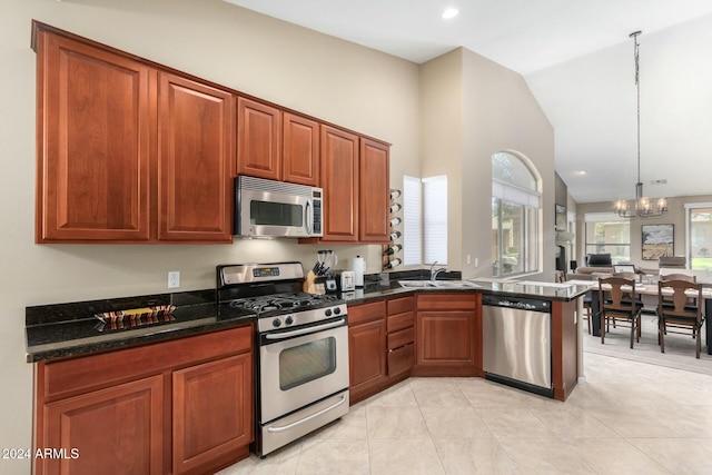 kitchen with an inviting chandelier, dark stone counters, lofted ceiling, decorative light fixtures, and appliances with stainless steel finishes