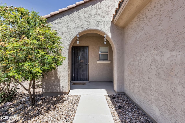 view of exterior entry featuring stucco siding