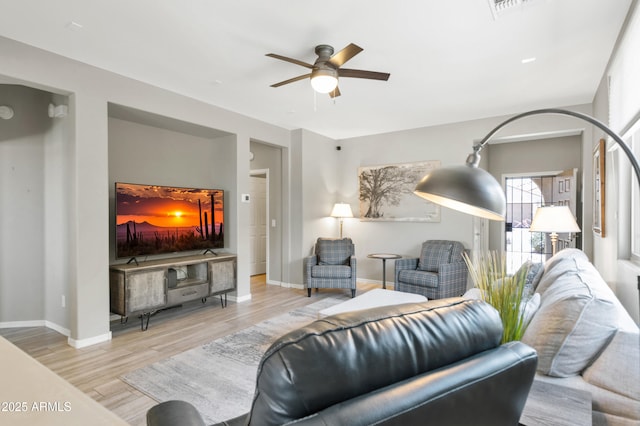 living room with a ceiling fan, wood finished floors, and baseboards