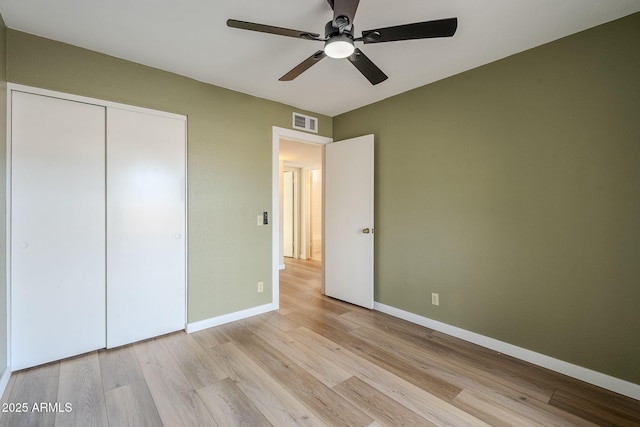 unfurnished bedroom with light hardwood / wood-style flooring, a closet, and ceiling fan