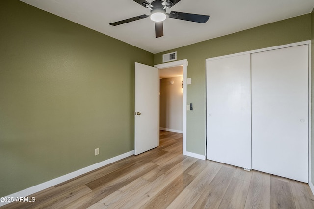 unfurnished bedroom with ceiling fan, a closet, and light wood-type flooring