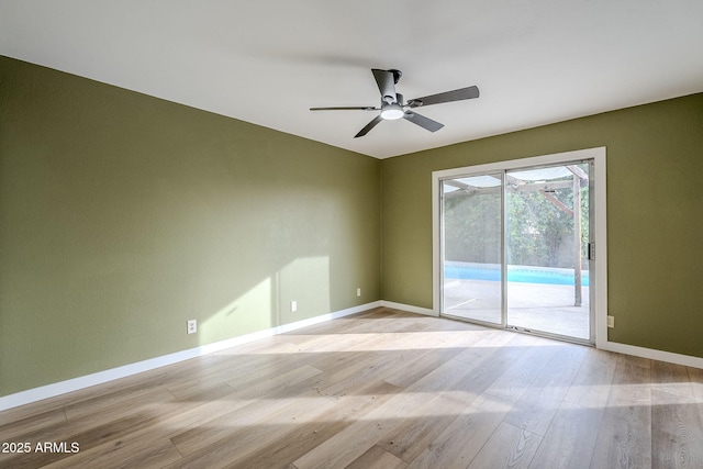 empty room with ceiling fan and light hardwood / wood-style flooring