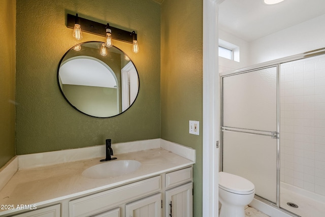 bathroom with vanity, toilet, and a shower with door