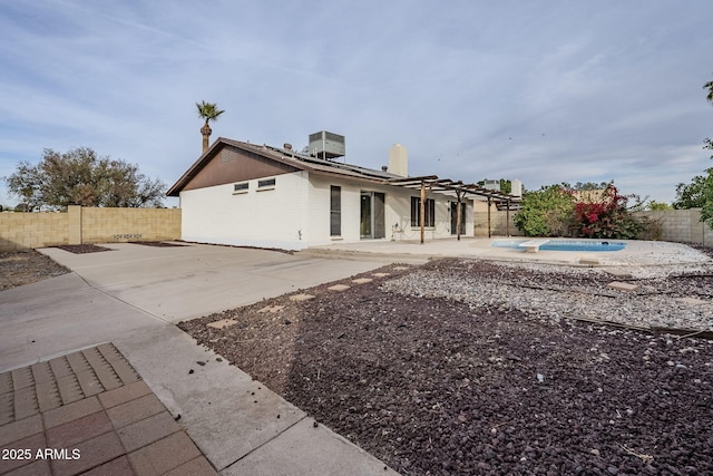 back of house with a patio area, a jacuzzi, and cooling unit