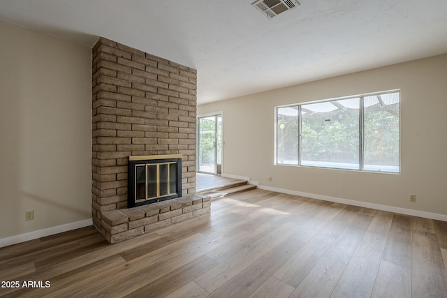 unfurnished living room with a fireplace and hardwood / wood-style floors