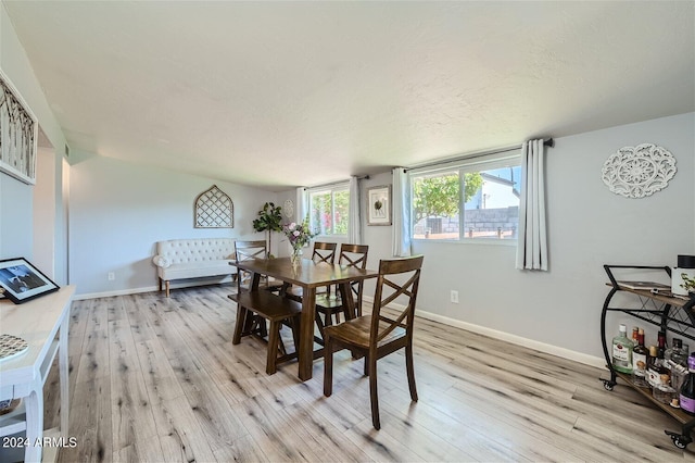 dining area featuring a textured ceiling and light wood-type flooring