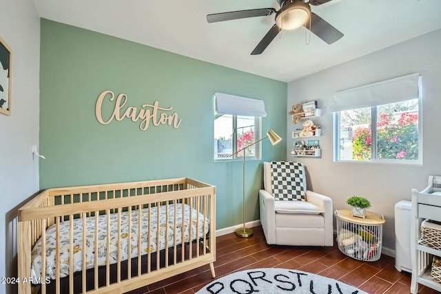 bedroom with a nursery area and ceiling fan