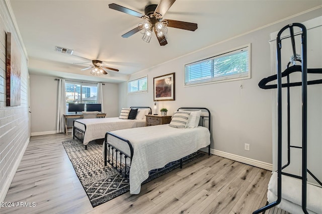 bedroom featuring ceiling fan, light hardwood / wood-style floors, and crown molding