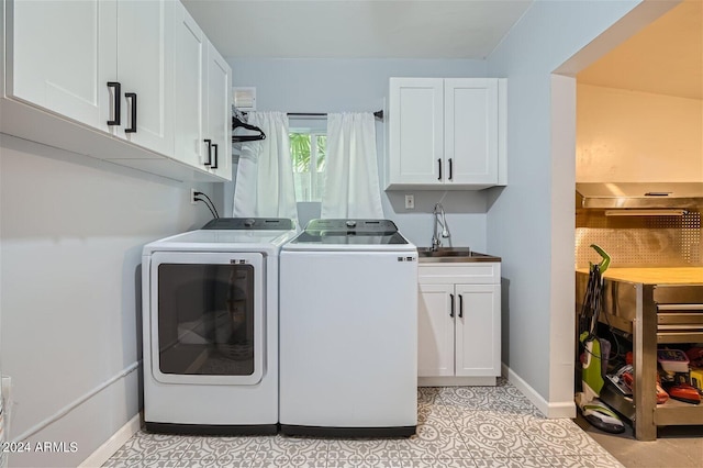 clothes washing area featuring light tile patterned flooring, cabinets, independent washer and dryer, and sink