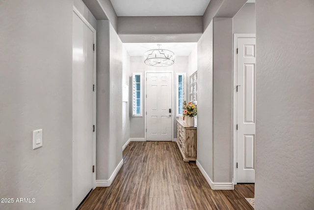 entrance foyer featuring an inviting chandelier and dark wood-type flooring