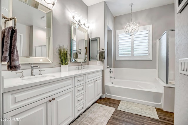 bathroom featuring a washtub, vanity, hardwood / wood-style floors, and a notable chandelier