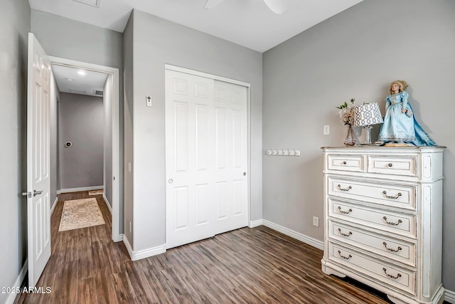 unfurnished bedroom featuring ceiling fan, a closet, and dark hardwood / wood-style floors