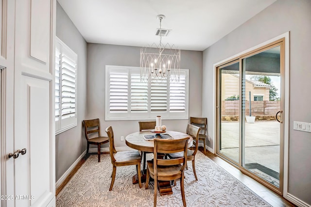 dining space featuring light hardwood / wood-style flooring and a chandelier