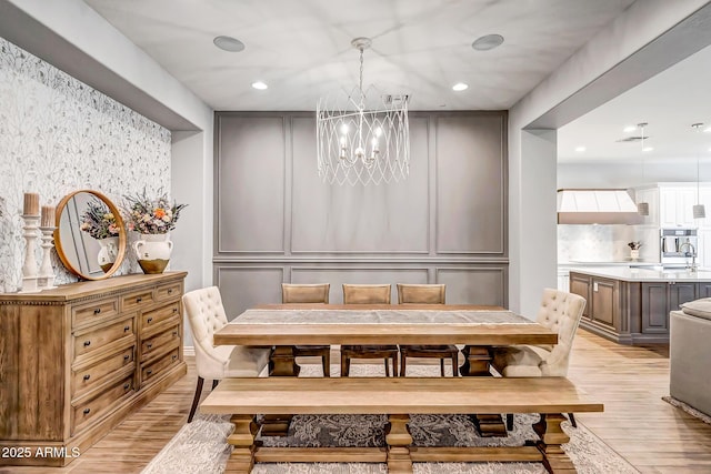 dining room featuring light hardwood / wood-style flooring and an inviting chandelier