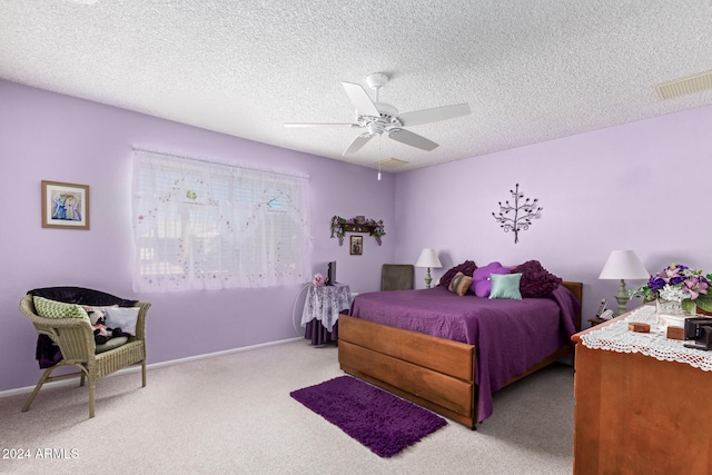 bedroom featuring ceiling fan, light colored carpet, and a textured ceiling